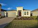 New single-story home with gray garage door and red front door at 16105 Old Fox Trl, Port Charlotte, FL 33953