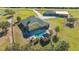 An aerial view showcases a home with a pool, tiki hut and expansive fenced yard, a barn, and a private drive at 25205 67Th E Ave, Myakka City, FL 34251