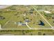 An aerial view captures a property with a home, barn, pond, and surrounding properties on a large lot at 25205 67Th E Ave, Myakka City, FL 34251