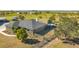 A high angle shot showcases the home with a tiki hut and fenced yard at 25205 67Th E Ave, Myakka City, FL 34251