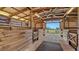 An interior shot of a barn featuring multiple stalls and a view of a large green field at 25205 67Th E Ave, Myakka City, FL 34251