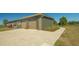 Large garage with multi-car parking, lush lawn and walkway to the home at 25205 67Th E Ave, Myakka City, FL 34251