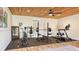 Home gym with wood plank ceiling, rubber floor, mirror and equipped with free weights and exercise machines at 25205 67Th E Ave, Myakka City, FL 34251