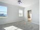 Sunlit bedroom featuring plush carpet, a ceiling fan, and large windows offering bright views at 4440 Tatum St, Port Charlotte, FL 33948