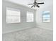 Bright bedroom featuring plush carpet, ceiling fan and large windows that bring in natural light at 4440 Tatum St, Port Charlotte, FL 33948