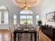 Bright dining room featuring a wooden table, tufted chairs, and a large window overlooking the greenery at 4440 Tatum St, Port Charlotte, FL 33948