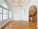 Bright dining room with hardwood floors, elegant chandelier, staircase, and large windows at 4440 Tatum St, Port Charlotte, FL 33948