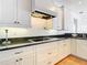 Kitchen area showcases granite counters, white cabinets, and stainless steel appliances at 4440 Tatum St, Port Charlotte, FL 33948