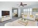 Open-concept living room showcasing a white sofa, glass coffee table, and modern decor at 4440 Tatum St, Port Charlotte, FL 33948