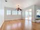 Living room with wood floors, ceiling fan, large windows, and sliding glass doors to the pool area at 4440 Tatum St, Port Charlotte, FL 33948