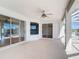 A covered patio features tile flooring, a ceiling fan, and multiple windows with views of the outdoors at 4440 Tatum St, Port Charlotte, FL 33948