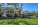 Tan house with palm trees and manicured lawn at 6836 Bay Hill Dr, Bradenton, FL 34202