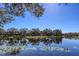 Scenic lake view with lush landscaping and reflections at 6836 Bay Hill Dr, Bradenton, FL 34202