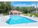 Community pool with lounge chairs and a cabana at 6836 Bay Hill Dr, Bradenton, FL 34202