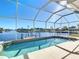 Enclosed pool and spa overlooking canal with sunny skies at 4440 Tatum St, Port Charlotte, FL 33948