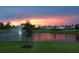 Aerial view of a community with lake, fountain, and houses at sunset at 16721 Barnwood Pl, Bradenton, FL 34211