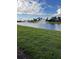 Serene lake view with lush green grass and fountain at 16721 Barnwood Pl, Bradenton, FL 34211