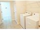 Bright laundry room with washer, dryer, and overhead shelving at 16721 Barnwood Pl, Bradenton, FL 34211