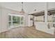 Bright dining area with wood floors, bay windows with a backyard view, and kitchen access at 5373 Dominica Cir, Sarasota, FL 34233