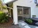 Exterior view of the screened-in porch/sunroom surrounded by lush landscaping at 5373 Dominica Cir, Sarasota, FL 34233