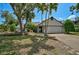 Charming single-story home featuring mature trees, a manicured lawn, and a two-car garage at 5373 Dominica Cir, Sarasota, FL 34233