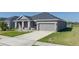 Single-story home with gray siding, two-car garage, and landscaped lawn at 16128 67Th E Ct, Parrish, FL 34219