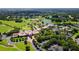 Aerial view of the beautiful community clubhouse, manicured lawns, a lake, and the golf course at 401 Walls Way, Osprey, FL 34229