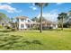 Spacious backyard featuring a lush green lawn and mature palm trees, perfect for outdoor activities at 401 Walls Way, Osprey, FL 34229