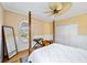 Bright bedroom featuring a four-poster bed, a ceiling fan, and a large window at 401 Walls Way, Osprey, FL 34229