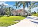 Charming exterior elevation with a large, well-manicured lawn and a long driveway at 401 Walls Way, Osprey, FL 34229