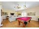 Spacious game room with pool table, tv, and comfortable seating area at 401 Walls Way, Osprey, FL 34229