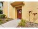 Townhouse exterior with a red door and well-maintained landscaping at 4990 Baraldi Cir # 101, Sarasota, FL 34235