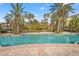 Expansive resort-style pool with palm trees and brick patio at 4990 Baraldi Cir # 101, Sarasota, FL 34235