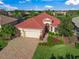 One-story house with tile roof, landscaping, and a paved driveway at 521 Luminary Blvd, Osprey, FL 34229