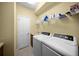 Bright laundry room with washer, dryer, and storage shelves at 521 Luminary Blvd, Osprey, FL 34229