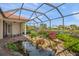 Relaxing screened patio with pond, waterfall, and seating area at 521 Luminary Blvd, Osprey, FL 34229