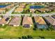 Aerial view of the homes featuring manicured lawns, screened lanais, and a serene pond in the community at 6870 Willowshire Way, Bradenton, FL 34212