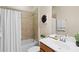 Well-lit bathroom featuring a shower-tub combo with tile surround, modern vanity, and decorative accents at 6870 Willowshire Way, Bradenton, FL 34212