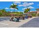 Row of colorful golf carts parked under palm trees near a building, offering convenient community transportation at 6870 Willowshire Way, Bradenton, FL 34212