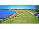 Scenic golf course view featuring lush green fairways, a tranquil lake, and nearby residential buildings under a clear blue sky at 6870 Willowshire Way, Bradenton, FL 34212