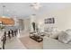 Cozy living room with neutral decor, a ceiling fan, and an arched entryway to the kitchen at 6870 Willowshire Way, Bradenton, FL 34212