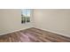 Spacious bedroom with wood-look floors and large window with shutters at 5762 Benevento Dr, Sarasota, FL 34238