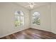 Bedroom with wood floors, ceiling fan and arched windows at 5762 Benevento Dr, Sarasota, FL 34238