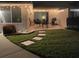 Evening view of backyard with patio, string lights, grill, and stepping stones at 7315 8Th W Ave, Bradenton, FL 34209