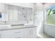 Elegant bathroom with double sinks, large mirror, and a walk-in shower at 5200 Highbury Cir, Sarasota, FL 34238