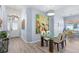 Bright dining area with glass table, beige chairs, and hardwood floors at 5200 Highbury Cir, Sarasota, FL 34238