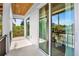 Covered balcony with sliding glass doors and view of tropical foliage at 551 S Washington Dr, Sarasota, FL 34236