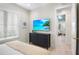 Bedroom with dark dresser, TV, and view into another bedroom at 551 S Washington Dr, Sarasota, FL 34236