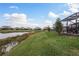 Backyard view of pond, landscaping, and community homes at 5554 Sand Fossil Ct, Sarasota, FL 34238