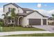 Two-story house with stone accents, three car garage, and landscaped yard at 5554 Sand Fossil Ct, Sarasota, FL 34238